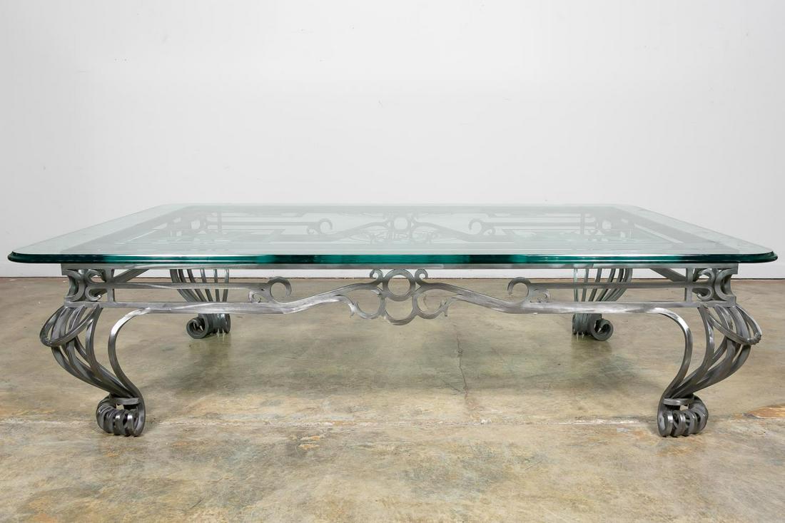 NEOCLASSICAL POLISHED STEEL ETCHED GLASS TABLE: Likely American, 20th century. Large glass and polished steel cocktail or coffee table, having a top etched with neoclassical iconography such as grapes, amphoras and lyres, on a scrolled steel base w