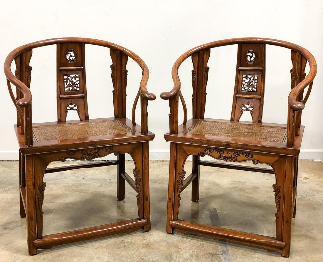 PAIR, CHINESE ELM HORSESHOE ARMCHAIRS: Chinese. Pair of elm horseshoe form armchairs having splats decorated with Chinese iconography such as bats, scrolled arms, woven panel seats and rising on squared legs with stretcher. Apparently unma