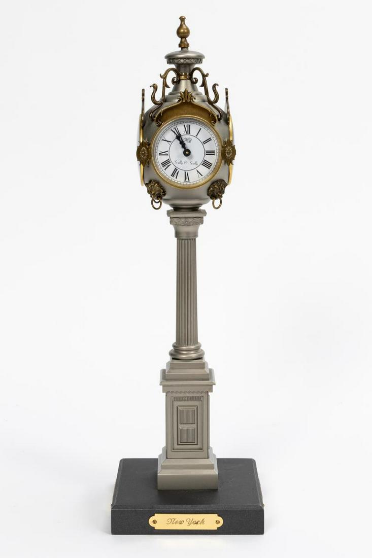 VICTORIAN STYLE COLUMN DESK CLOCK, SCULLY & SCULLY: Scully & Scully, contemporary. Desk top Victorian style miniature quartz movement time zone clock, having a scrolled silver-tone body with four faces and plaques underneath for "New York", "San Franci