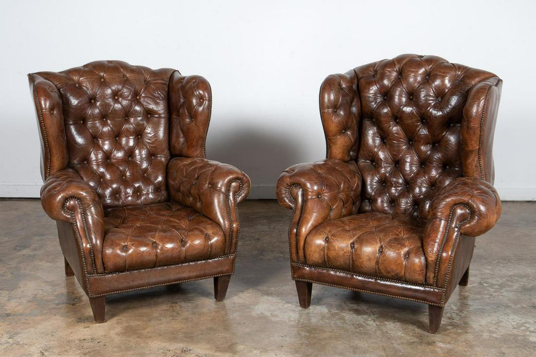 PAIR, TUFTED BROWN LEATHER WINGBACK CHAIRS: Pair of Edwardian style brown leather tufted wingback chairs having rolled arms and rising on front tapered legs. Unmarked. Approx. of one, h. 43.5", w. 38.5", d. 27".