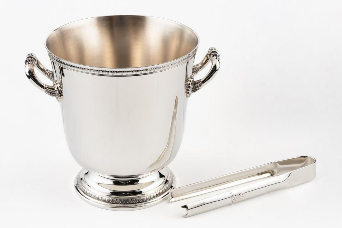 CHRISTOFLE "MALMAISON" ICE BUCKET & TONGS: Christofle, contemporary. A silver plated "Malmaison" footed ice bucket in the Empire taste having double handles and palm and lotus leaf detail, together with a pair of tongs. Marked to the underside