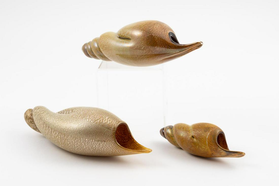 3 SEGUSO SNAIL FORM GLASS GOLD TWISTED SHELLS: Seguso Viro Co. (Italian), contemporary. Group of three murano blown glass "conchiglie" snail shell form glass pieces with gold flecks. Approx. h. 9" (largest), h. 5" (smallest)