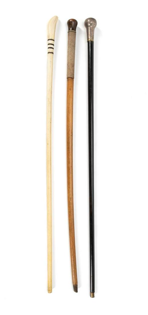 THREE VINTAGE ENGLISH WALKING STICKS, 1 STERLING: English, Early 20th Century. Consisting of a bone & rosewood cane, an oak cane with shagreen wrapping and rosewood knob and an ebonized cane with machine engraved sterling head hallmarked London, Henr
