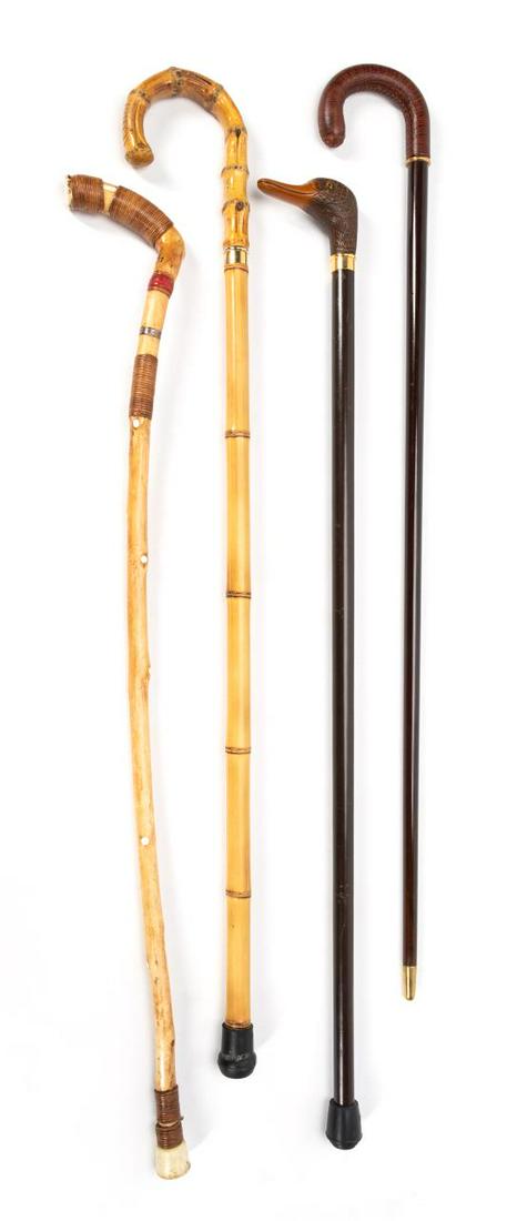 4 VINTAGE CANES INCLUDING DUCK HEAD & INLAY: 20th Century. Consisting of a mahogany cane with molded duck head handle, a mahogany cane with lizard embossed leather curved handle, a bamboo cane with curved bamboo handle, and a natural stick cane 