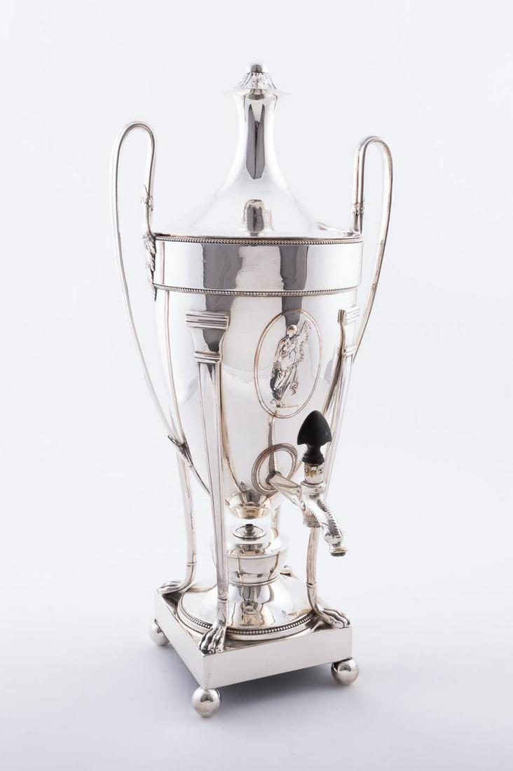 NEOCLASSICAL STYLE SHEFFIELD PLATE HOT WATER URN: English, early 19th century. A George III hot water urn in the Neoclassical taste with Chinese dolphin form spout, scrolled handles, figural medallions to front and verso, column style legs with paw f