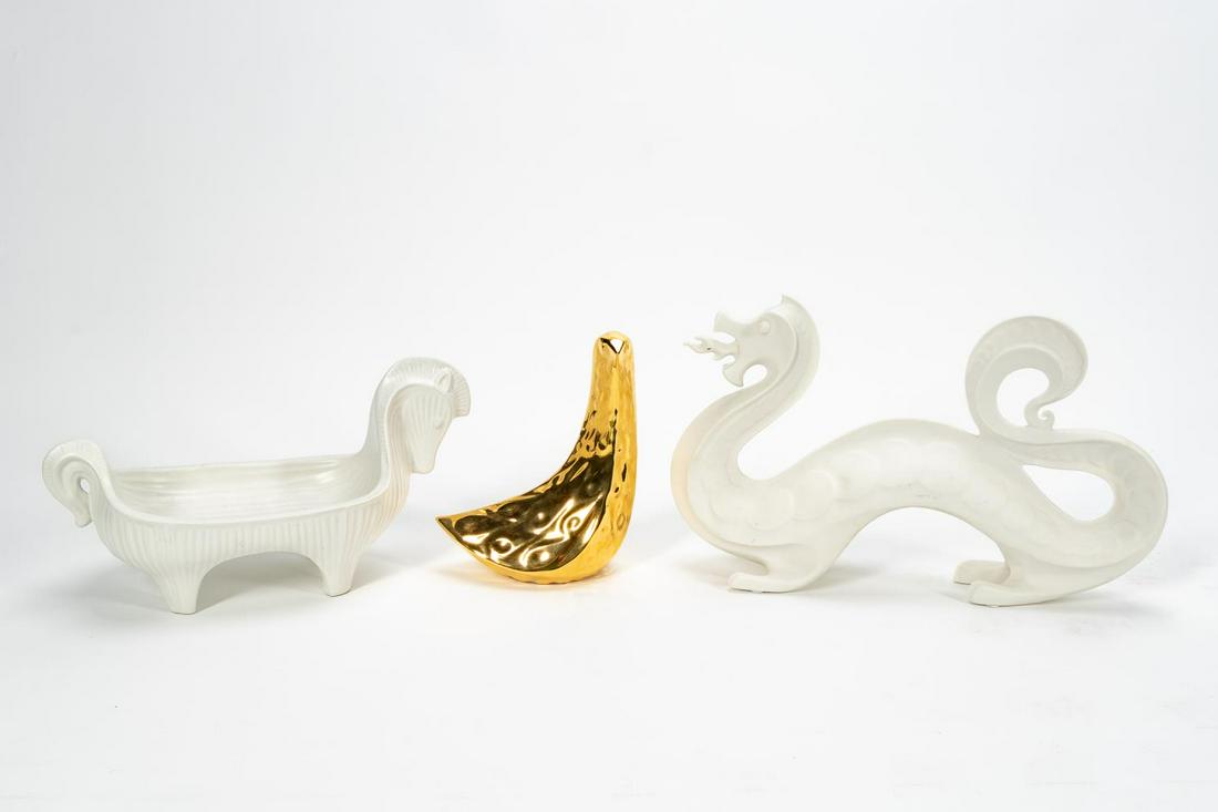 3 JONATHAN ADLER DECORATIVE CERAMIC OBJECTS: Jonathan Adler (American, b. 1966), contemporary. A group of three decorative ceramic pieces comprising of one bisque dragon figurine, modern style gold bird figurine, and one bisque Trojan style hors