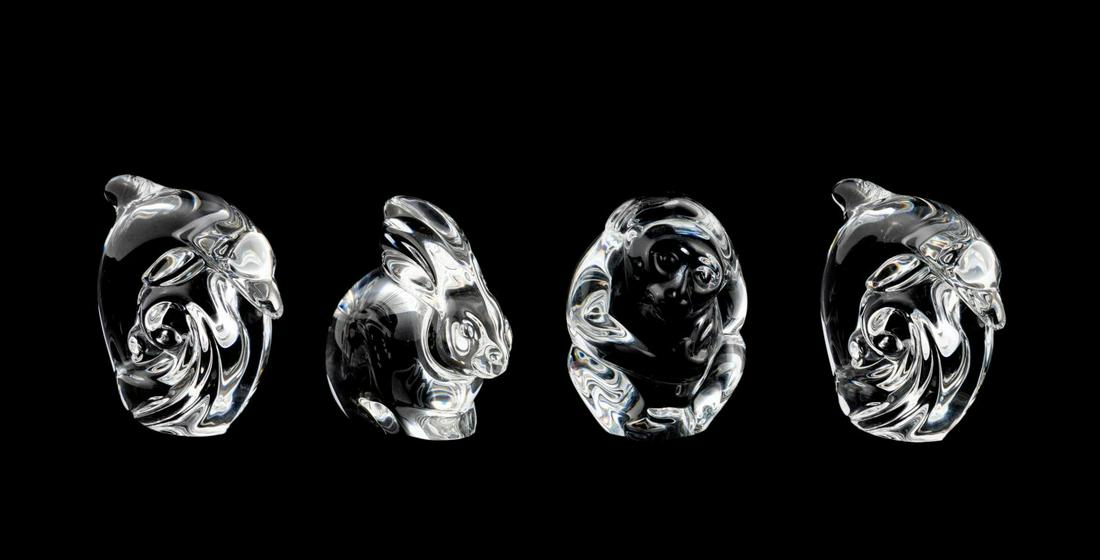 FOUR STEUBEN CRYSTAL ANIMALS FIGURES: Steuben, contemporary. Group of four colorless glass figurines comprising of two dolphins, one monkey, and one rabbit. Etched maker's mark to underside. Approx. h. 2.5" (dolphin), h. 2.375" (rabbit).