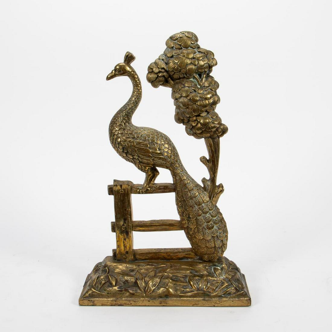 CAST BRASS PEACOCK DOORSTOP, EARLY 20TH C.: American or English, Early 20th Century. Cast and polished brass figural doorstop depicting a peacock stand on a rail fence beside a tree, cast foliate base. Iron weighted base. Apparently unsigned. A