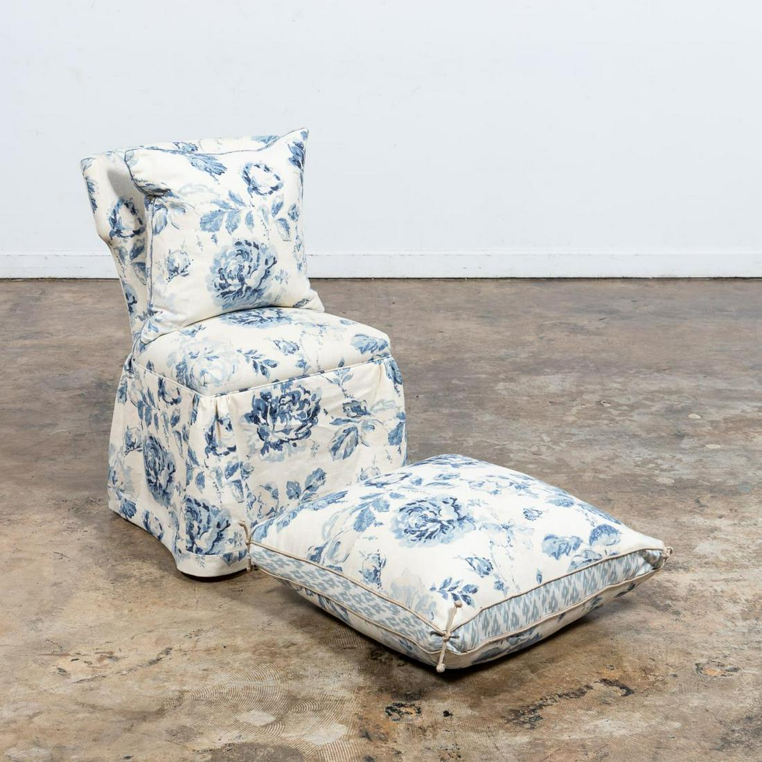 CUSTOM UPHOLSTERED SLIPPER CHAIR W/ TWO PILLOWS: American, Late 20th century. Fully upholstered armless chair with a skirted base, blue floral on ivory printed fabric, with two square pillows in the same fabric. Approx. h. 34.5", w, 20" (chair), app