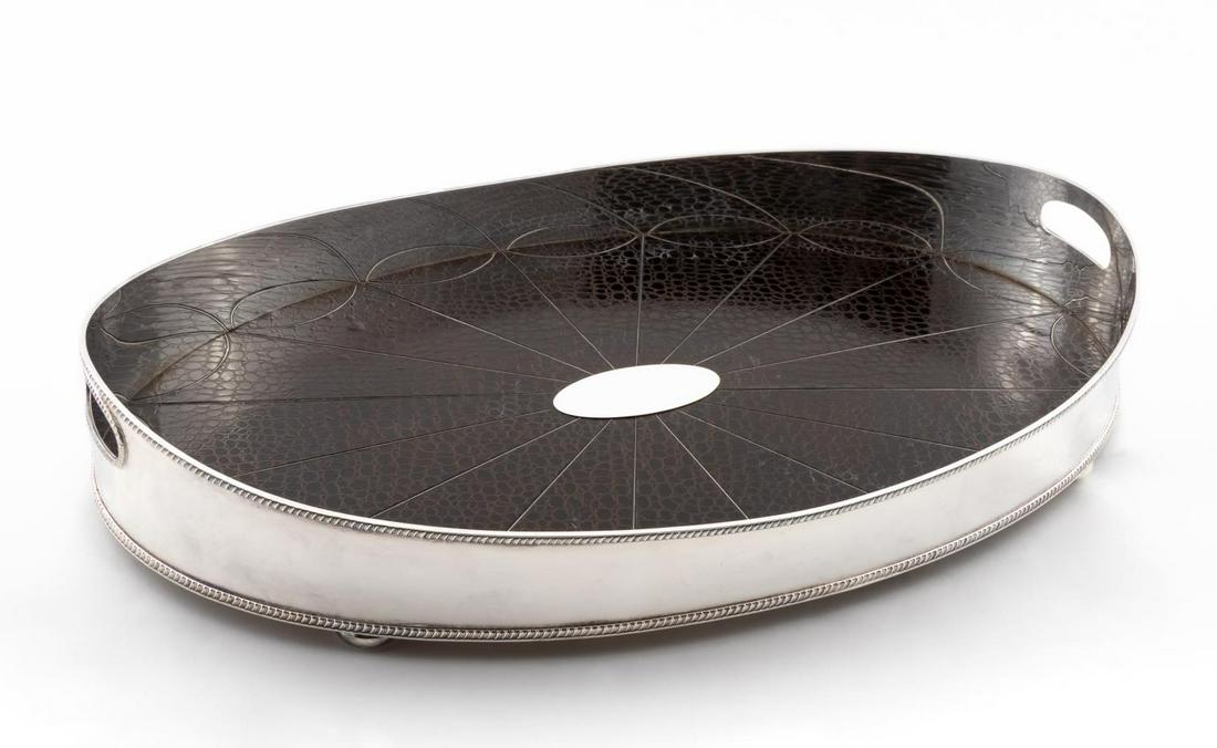 LARGE SILVER PLATE & FAUX CROCODILE BUTLER'S TRAY: Likely English, late 20th to 21st century. Large silver plate and faux crocodile oval butler's tray having gardooned edges, double handles, oval plaque, and rising on flattened ball feet. The undersid