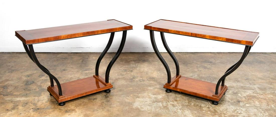 *PAIR, ART DECO PERIOD CONSOLE TABLES W/ EBONY: Continental, second quarter 20th century. Pair of Art Deco console tables having walnut tops and bases, curved ebonized supports and rising on bun feet. Unmarked. Approx. of one, h. 32", w. 51", d. 18