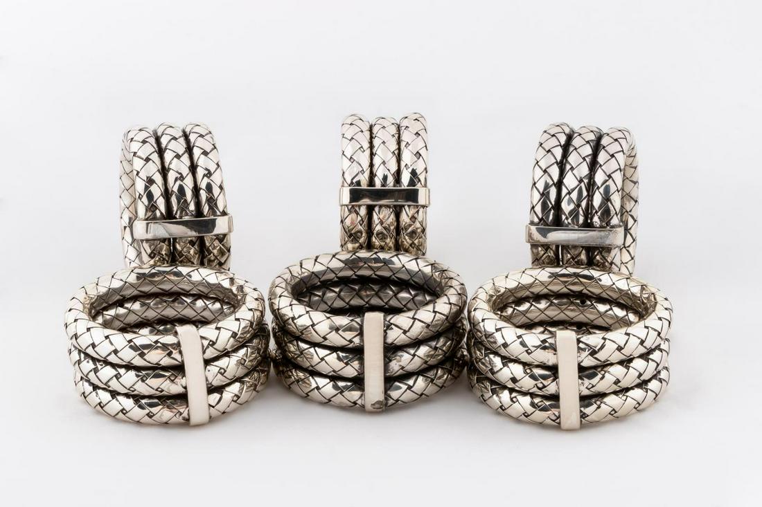 6 BOTTEGA VENETA SILVER PLATE WOVEN NAPKIN RINGS: Bottega Veneta, contemporary. A set of six silver plated intrecciato detail napkin rings. Including three dust bags. Maker's mark to interior and Made in Italy. Approx. h. 1", diam 2.25".