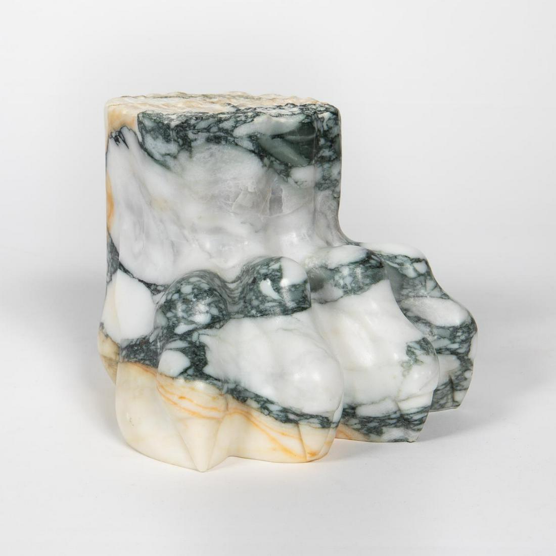 KELLY WEARSTLER CARVED MARBLE PAW FOOT STAND: Kelly Wearstler, contemporary. A carved gray and white marble lion's paw table accessory with polished foot and raw cut top. Etched signature to underside. Provenance: Acquired from Bergdorf Goodman i