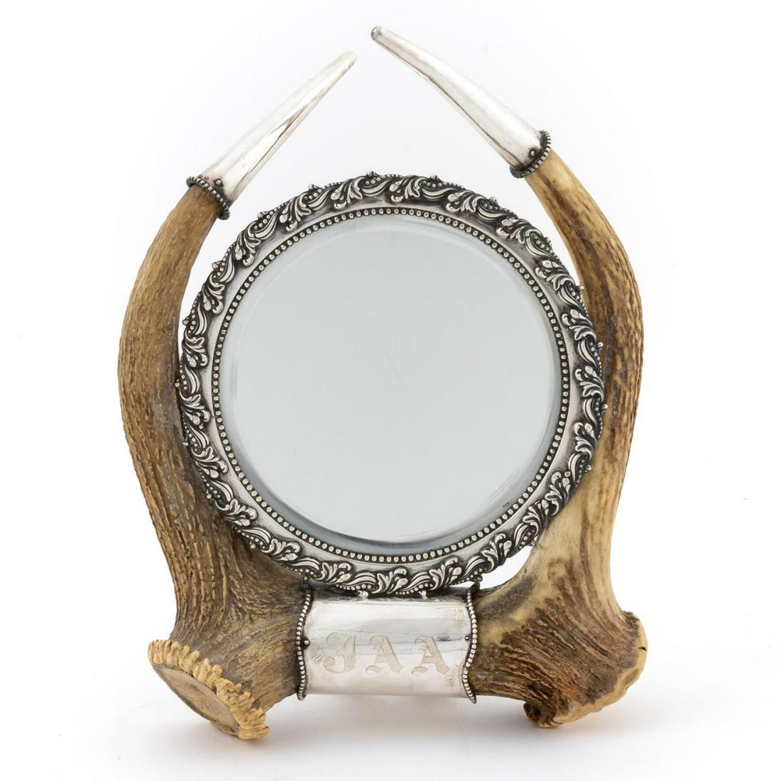 STERLING MOUNTED ANTLER DRESSING MIRROR: Redlich & Co. (American, 1890-1946), late 19th to early 20th century. American sterling silver mounted double antler dressing or shaving mirror having a circular beveled plate with acanthus and beaded