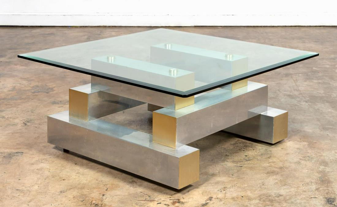 GLASS & METAL COFFEE TABLE, MANNER OF PAUL EVANS: In the manner of Paul R. Evans (American, 1931-1987), fourth quarter 20th century. Gilt and silvered metal Cityscape-style coffee or cocktail table having a square glass top with beveled edge supporte