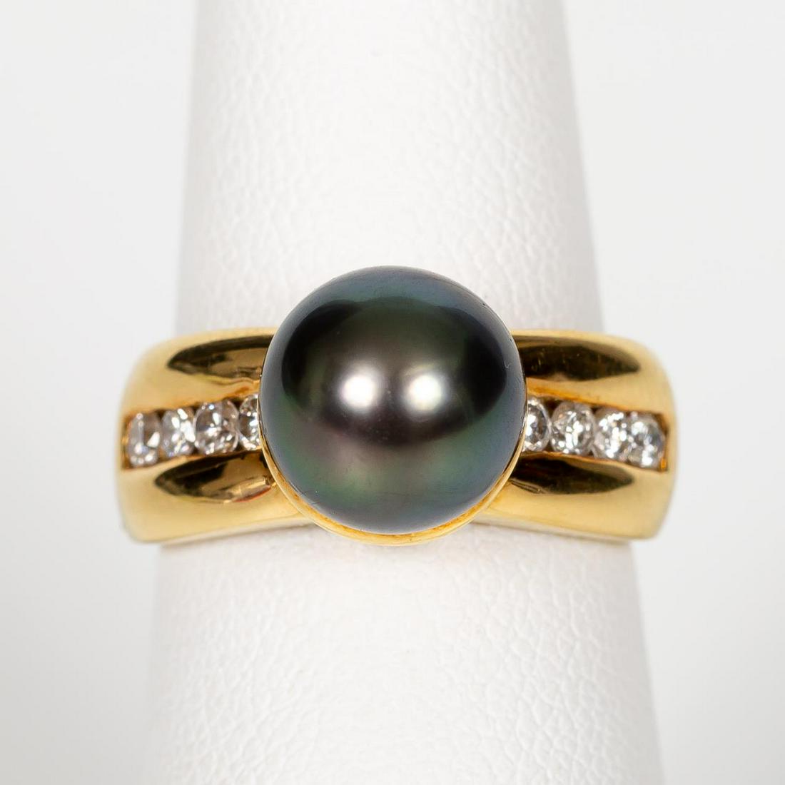 18K GOLD, BLACK TAHITIAN PEARL & DIAMOND RING: An 18k yellow gold and pearl ring comprising of a black cultured Tahitian pearl (diam. 9.43mm) and channel set round diamonds (0.50 ctw). Marked to interior, 18KT and makers initials in circle. Approx
