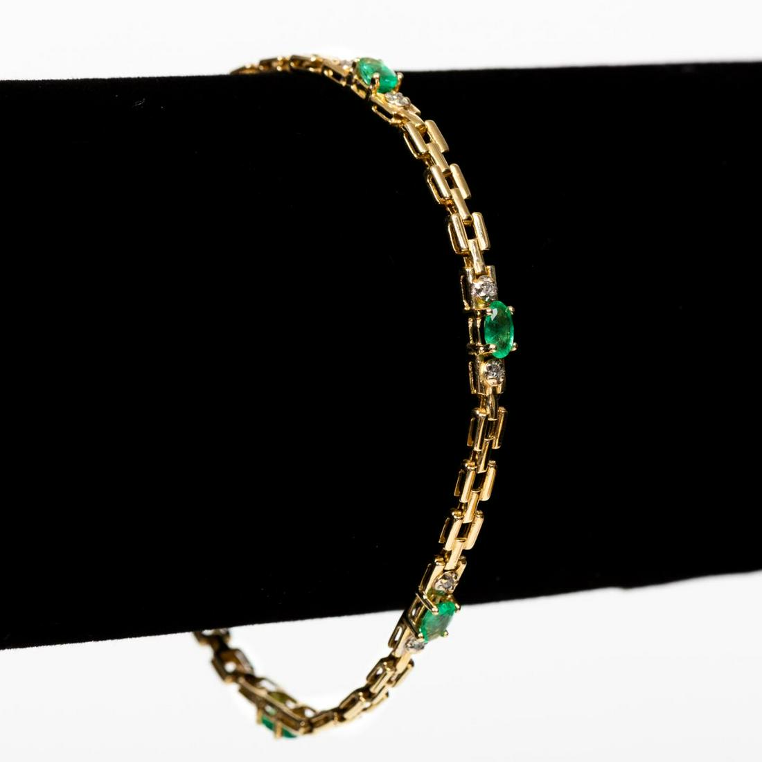 14K GOLD, EMERALD, & DIAMOND LINK BRACELET: A 14k yellow gold link bracelet set with five oval emeralds (approx. 1.00ctw, color: bright medium green, clarity: i1) and accented with small diamonds set in white gold. Marked for 14k gold quality. 
