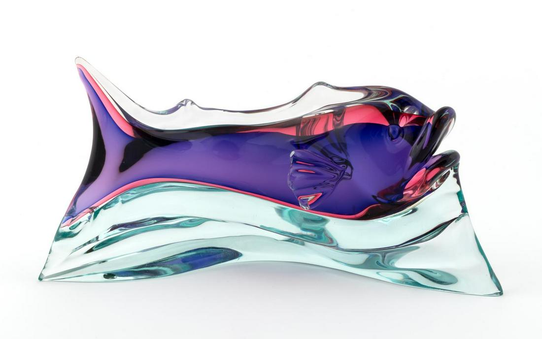 MURANO ART GLASS FISH IN THE STYLE OF SEGUSO: Italian, 20th century. An art glass fish with clear to pink to purple body raised on a aqua tinted blue wave of water. Apparently unmarked.. Approx: h. 6.25", w. 12.25", d. 5.5"