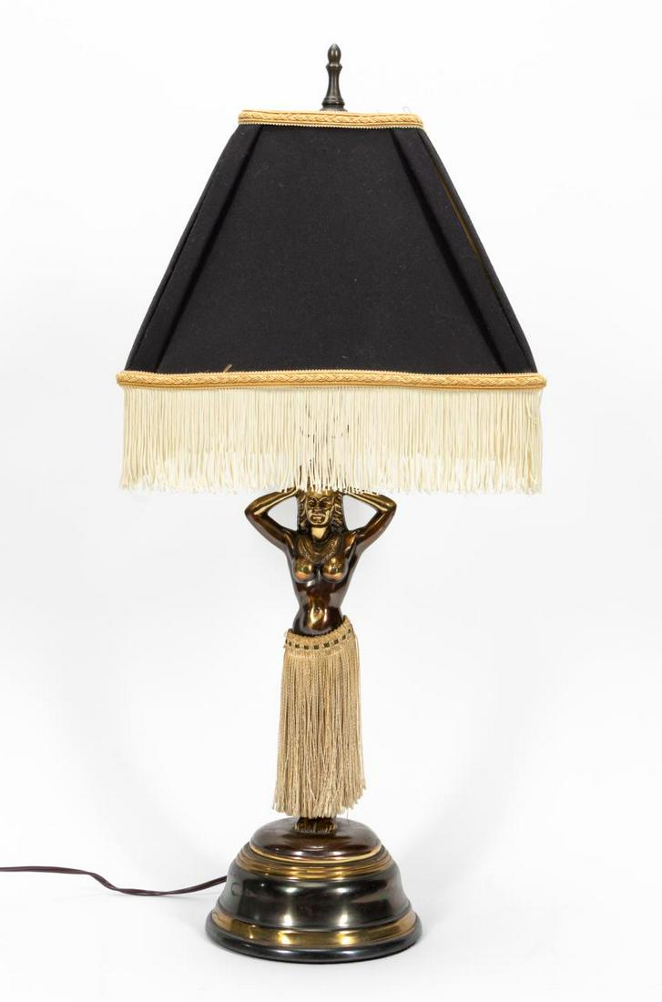 ANIMATED HULA DANCER TABLE LAMP WITH SHADE: American, 20th century. Table lamp in the shape of a hula dancer wearing cloth fringe imitating a grass skirt. Three settings allow either her hips to gyrate only, light only, or both gyrations and li