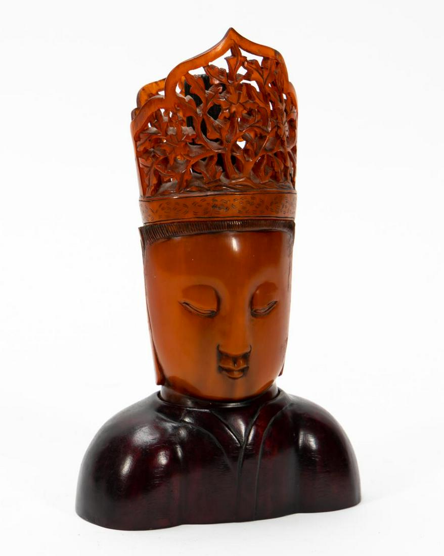 CHINESE CARVED OX HORN BUDDHA HEAD ON WOOD BASE: Chinese. A carved ox horn Buddha head bust on wooden base with a carved figural ox hoof to the interior. Apparently unmarked. Approx: h. 8.5", w. 5.375", d.3".