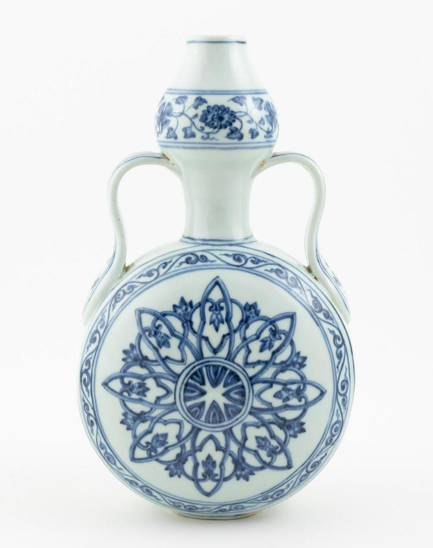 CHINESE BLUE AND WHITE PORCELAIN MOONFLASK: Chinese. A blue and white porcelain moon flask with foliate decoration to upper rim. Six character mark present to upper rim.Approx: h. 10.375", w. 6", d. 4".