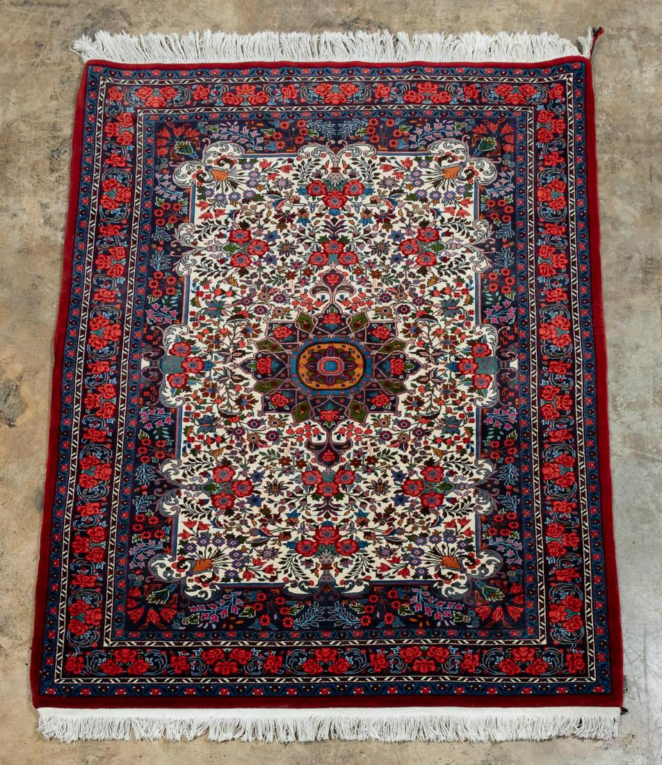 HAND WOVEN PERSIAN RUG, APPROX. 5' 4" X 3' 10": Iran, late 20th century. A wool on cotton throw rug with a central medallion on an ivory field with broken border, design of bright red flowers framed by a navy border and fringed ends.Approx. 5'4" x 