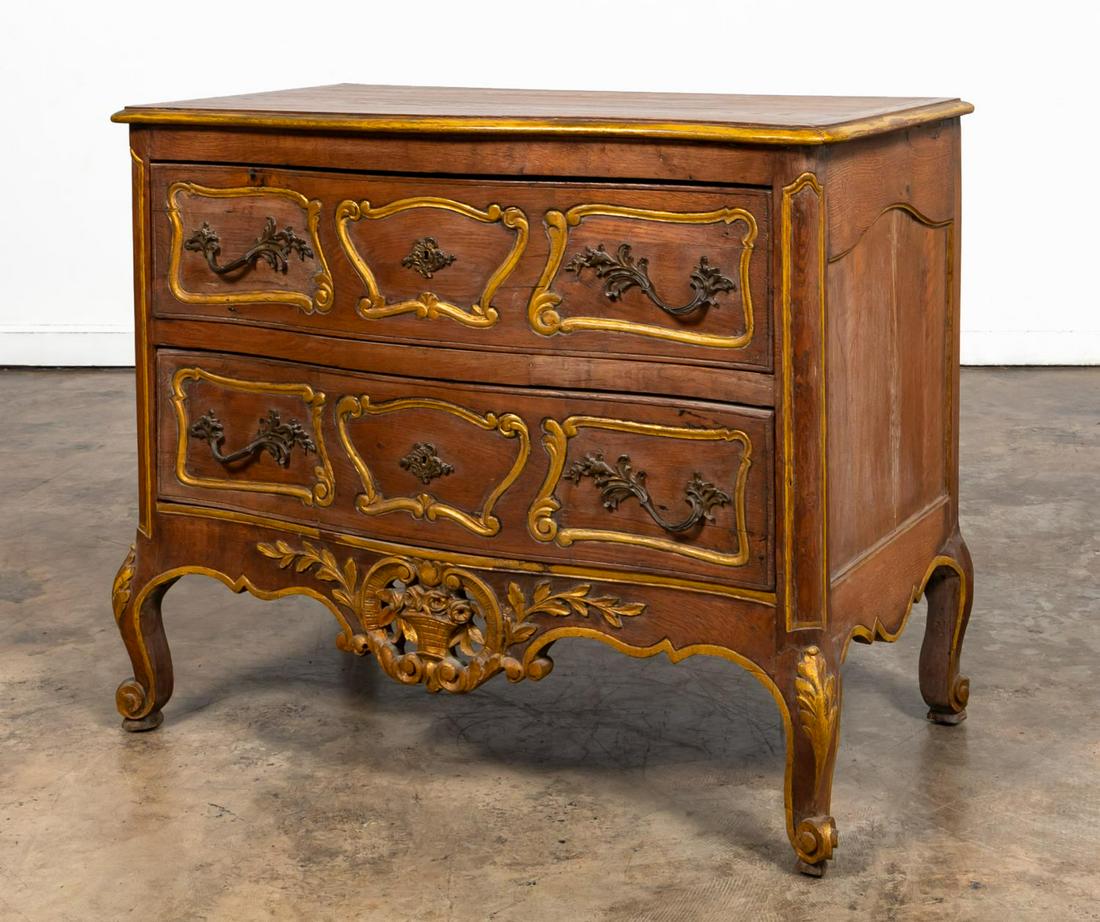 FRENCH OAK TWO DRAWER PROVINCIAL COMMODE: French, late 19th/ early 20th century. Provincial Louis XV style two drawer commode with drawer fronts having scroll carved panels and cast brass hardware, flower basket pierce-carved skirt, on short