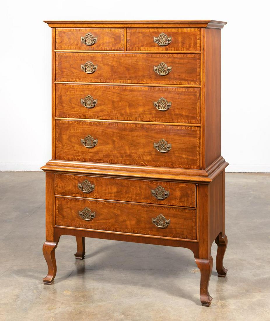 BAKER MILLING ROAD CHERRY & OAK HIGHBOY: American, 20th century. A Georgian style highboy in cherry and oak, single piece construction, with cornice molded top over two small and five long oak crossbanded drawers, on four cabriole legs. Bran