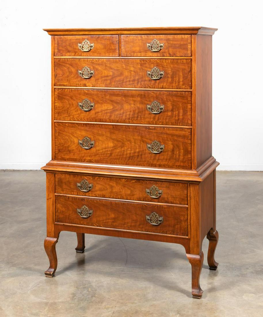 BAKER MILLING ROAD CHERRY & OAK HIGHBOY: American, 20th century. A Georgian style highboy in cherry and oak, single piece construction, with cornice molded top over two small and five long oak crossbanded drawers, on four cabriole legs. Bran