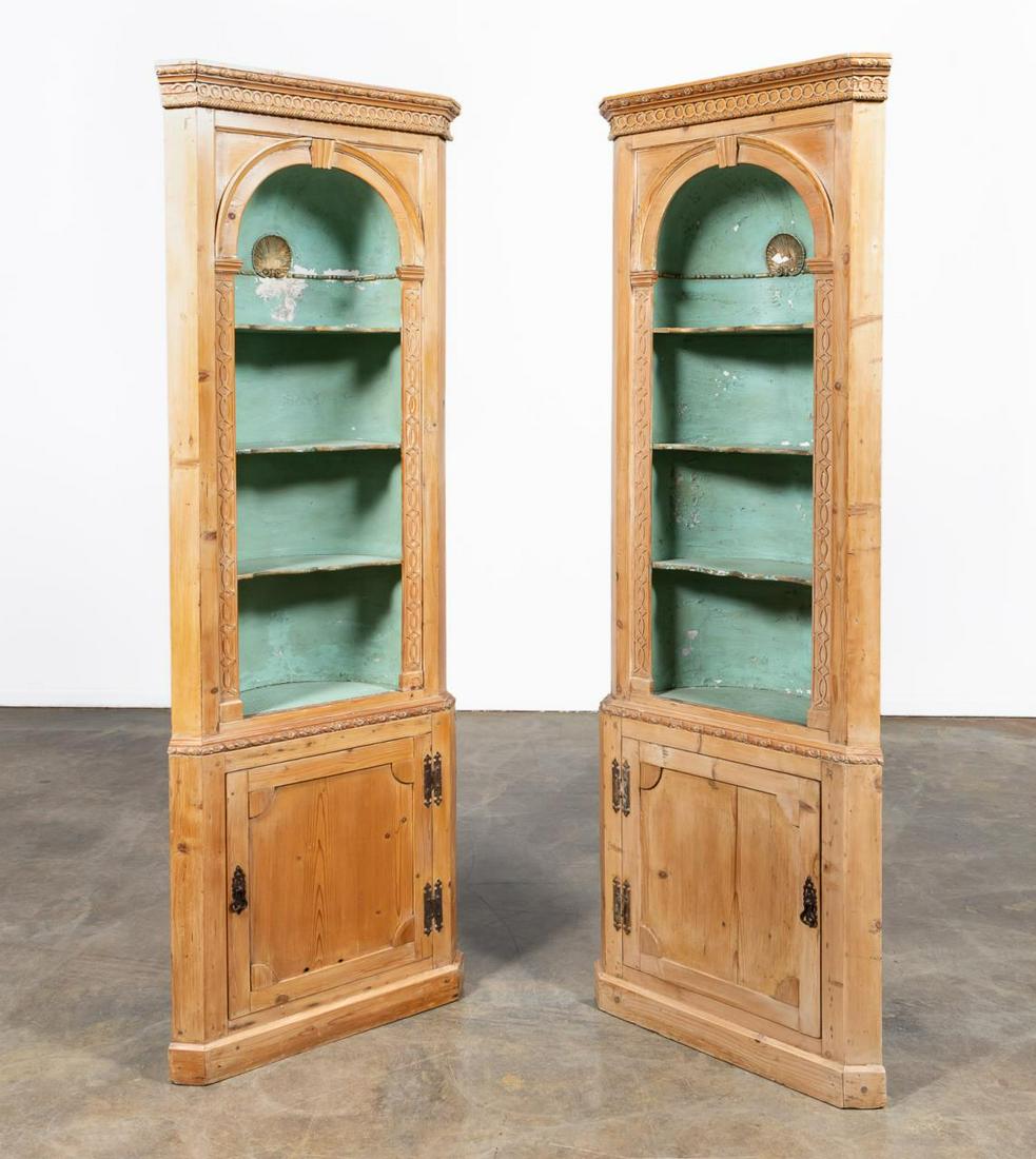 PAIR OF PINE ARCHITECTURAL CORNER CUPBOARDS: American, late 19th/ early 20th century. Georgian Revival style having molded cornices over arch top open barrel back display niches with fixed shelves and painted interiors, applied cast composition 