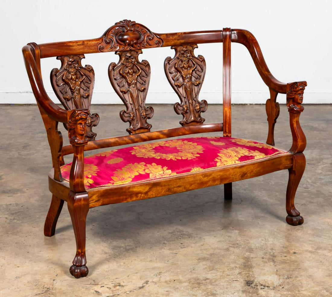 ART NOUVEAU STYLE FIGURAL MOTIF SETTEE: American, early 20th century. Mahogany finished Art Nouveau style settee with cartouche carved crest rail over three urn splats with applied figural "molded" carving, the arms with women's head termin