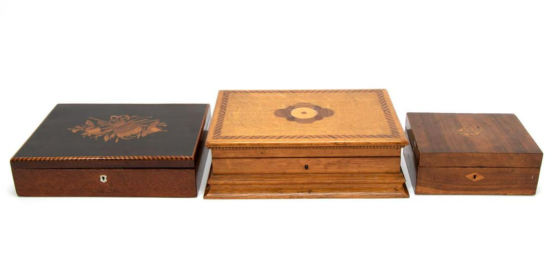 THREE WOODEN INLAID DECORATIVE BOXES, 19TH/ 20TH C: English, 19th to early 20th century. Collection of three inlaid wooden boxes comprising oak with inlaid top and divided interior, inlaid with fabric interior, and marquetry top.Approx. h. 4.5" w. 14.5