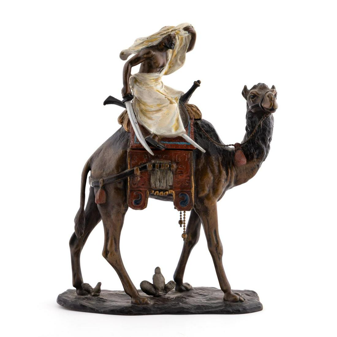 AUSTRIAN COLD PAINTED BRONZE CAMEL & RIDER INKWELL: Manner of Franz Bergman (Austrian, 1898-1963). Cold painted bronze depicting Northern African rider with sword drawn astride a camel. Hinged rider tilts to reveal an inkwell with porcelain cup. Marked