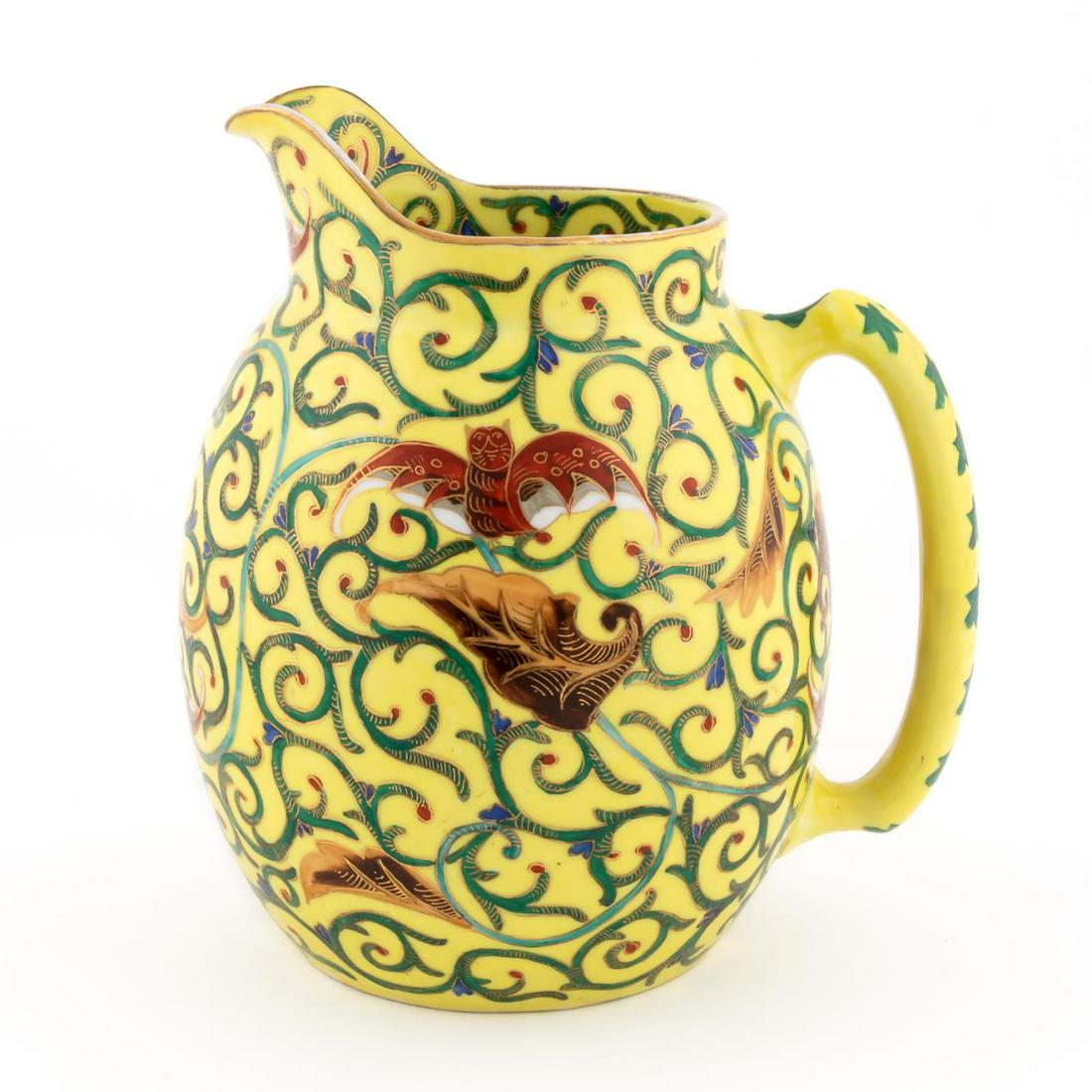 AUSTRIAN ENAMELED "CHINTZ" PATTERN WATER PITCHER: Austrian, early 20th century. A yellow ground porcelain water pitcher with heavily gilt decorated vining and bat forms to main body. Beehive mark to underside.Approx: h. 8.25", w. 6.25", d. 7.5".