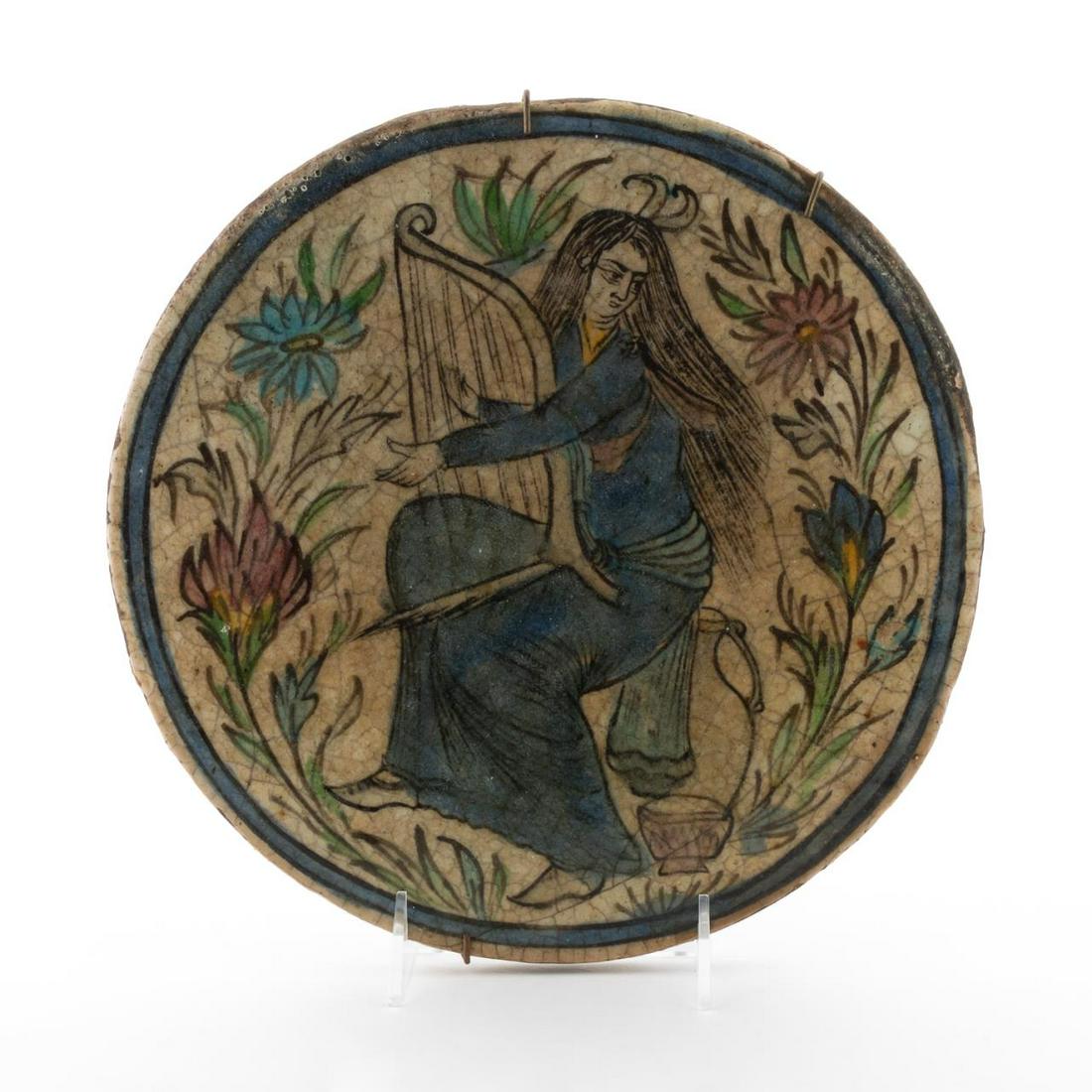 19TH CENTURY, PERSIAN ARCHITECTURAL MUSIC TILE: Persian, 19th century. A round ceramic glazed architectural tile depicting a young lady playing the harp. No markers mark present.Approx: 10.75".