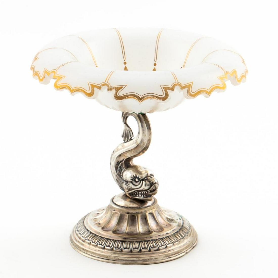 CONTINENTAL SILVER & MILK GLASS DOLPHIN COMPOTE: Continental, circa 1900. A sterling silver figural dolphin and glass compote having hand painted gilt accents to bowl. Apparently unmarked.Approx: h. 7", w. 7.25".