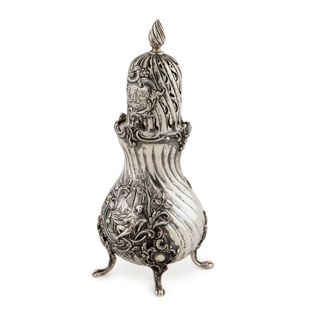 19TH C., DUTCH .833 SILVER ORNATE SUGAR SHAKER: Dutch, late 19th century. A .833 silver sugar shaker with ornate twisted form body, figural landscape to body, Dutch harbor scene to topper and resting on four paw feet. Marked to bottom with Dutch li