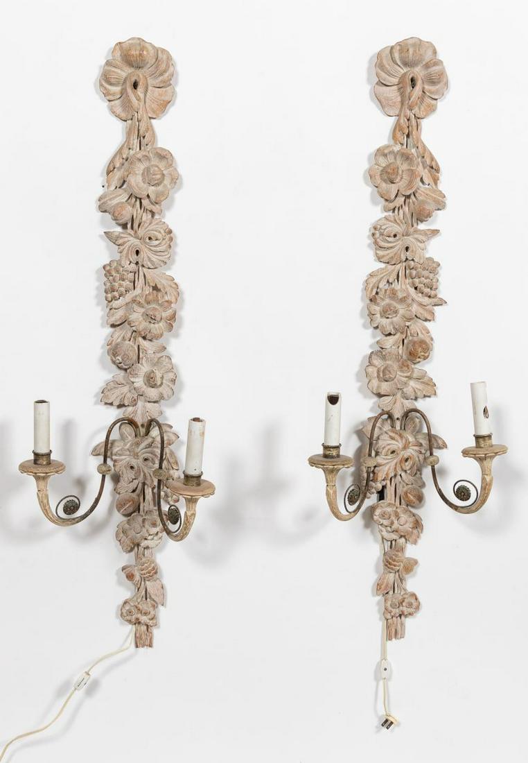 PR. CONTINENTAL LIMED OAK 2-ARM WALL SCONCES: Continental, 20th century. Pair of carved and limed oak two light wall sconces, fruit & flower motif with metal & wood scrolling arms. Apparently unmarked.Approx. h. 42.75", w. 13.5", d. 7"