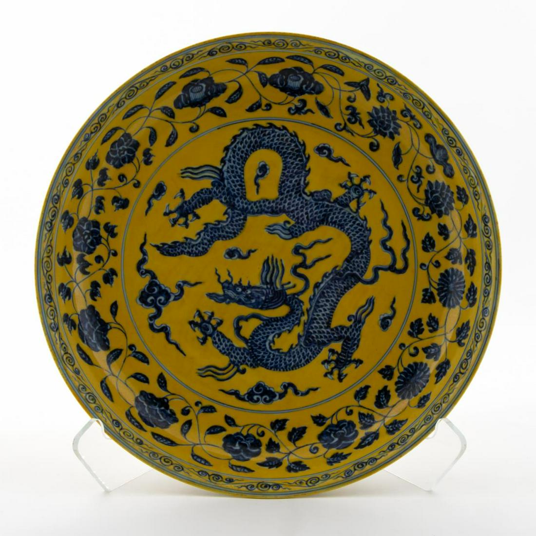 CHINESE MING TYPE FAMILLE JAUNE DRAGON CHARGER: Chinese. Ming type famille jaune porcelain charger decorated with a blue five-toed dragon encircled by florals on a yellow ground. Unmarked. Approx. h. 3", dia. 15.5".