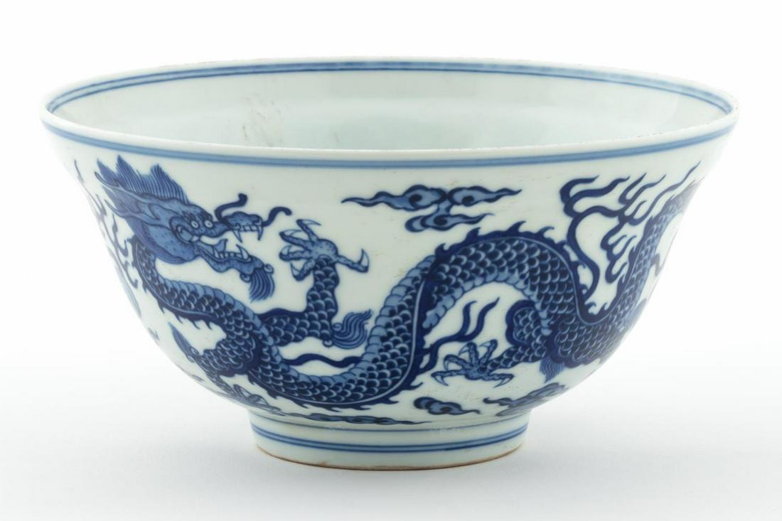 SMALL CHINESE BLUE & WHITE DRAGON MOTIF BOWL: Chinese. Small blue and white porcelain bowl decorated with multiple five-toed dragons, two chasing a flaming pearl, the foot with a double ring. Blue Qianlong type mark to the underside in a double b