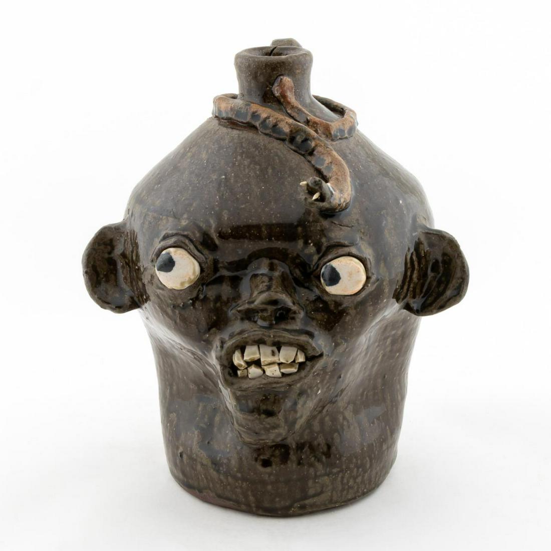 FACE JUG, CHESTER HEWELL, SOUTHERN POTTERY: Chester Hewell (American/Georgia, born 1950). "Face Jug", stoneware. Signed underneath. Approx. h. 10.5"