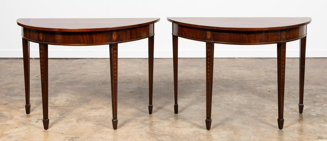 PAIR OF HEPPLEWHITE STYLE MAHOGANY DEMILUNE TABLES: Likely English, 20th century. Pair of mahogany demilune console tables in the Hepplewhite taste having patera inlaid tops with bell flowers to the tapered legs with spade feet. Unmarked. Approx. of on