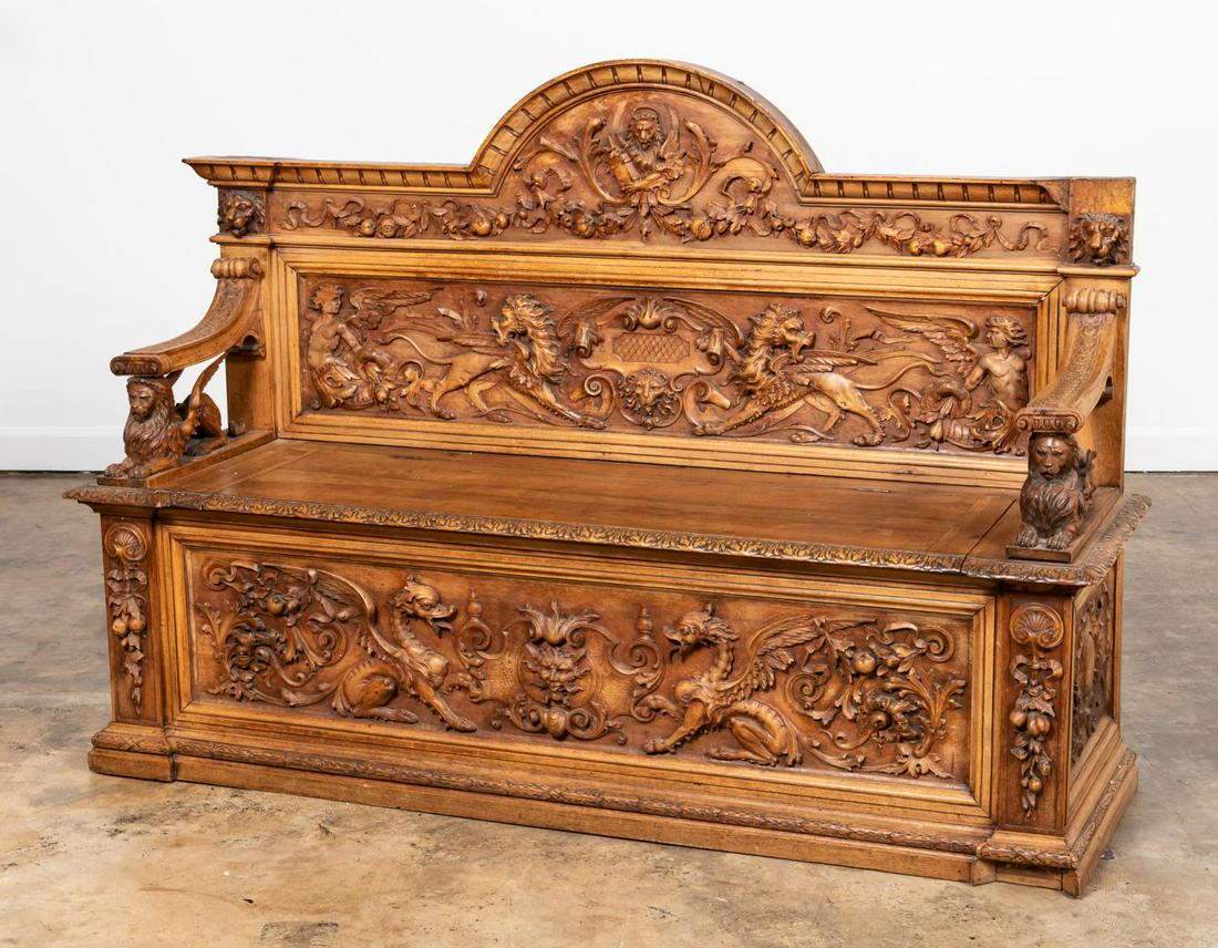19TH C. RENAISSANCE REVIVAL HORNER STYLE BENCH: American, late 19th century. Well carved Renaissance revival oak hall bench in the manner of R.J. Horner, having an arched back, guilloche patterned arms lift-top seat, and decorated with winged lions