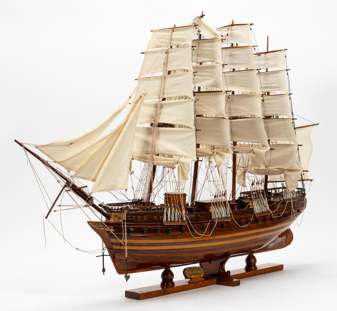 WOODEN MODEL OF A SHIP ON STAND, "NEW IYLAND": American, 20th century. Wood, cloth and metal model of the "New Iyland", a cannon-armed four mast frigate on stand. Titled on rear of ship and plaque on stand. Approx. h. 29", w. 35"
