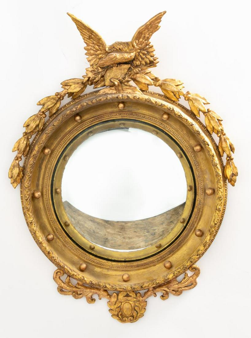 AMERICAN FEDERAL CONVEX GILTWOOD MIRROR: American, early 20th century. Federal style gilt wood convex mirror having eagle crest and lower laurel leaf wreath. Apparently unmarked. Approx. h. 37", w. 26".