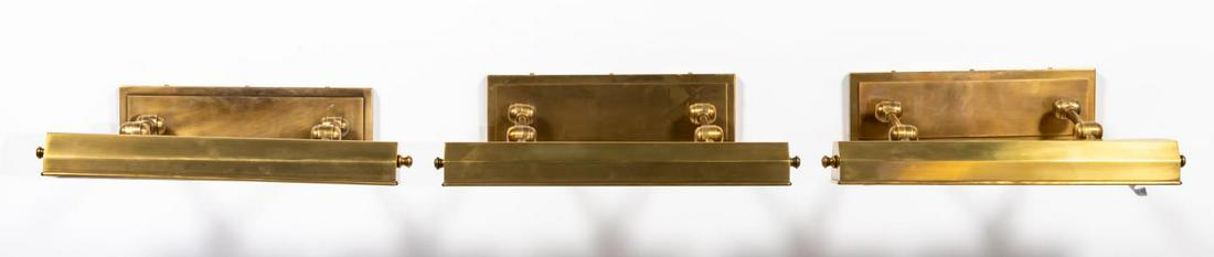 SET, THREE BRASS DORCHESTER PICTURE LIGHTS: E.F. Chapman (American, 20th century), contemporary. Set of picture or wall mounted 'Dorchester' library lights, each having an antique brass burnished finish, adjustable shade, and rectangular backpl