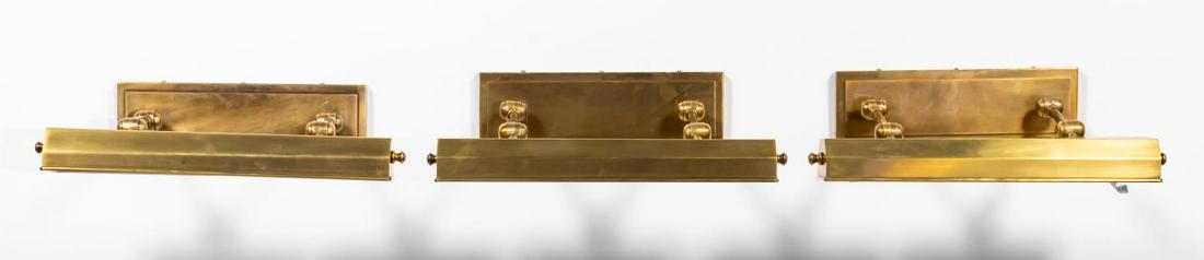 SET, THREE BRASS DORCHESTER PICTURE LIGHTS: E.F. Chapman (American, 20th century), contemporary. Set of picture or wall mounted 'Dorchester' library lights, each having an antique brass burnished finish, adjustable shade, and rectangular backpl