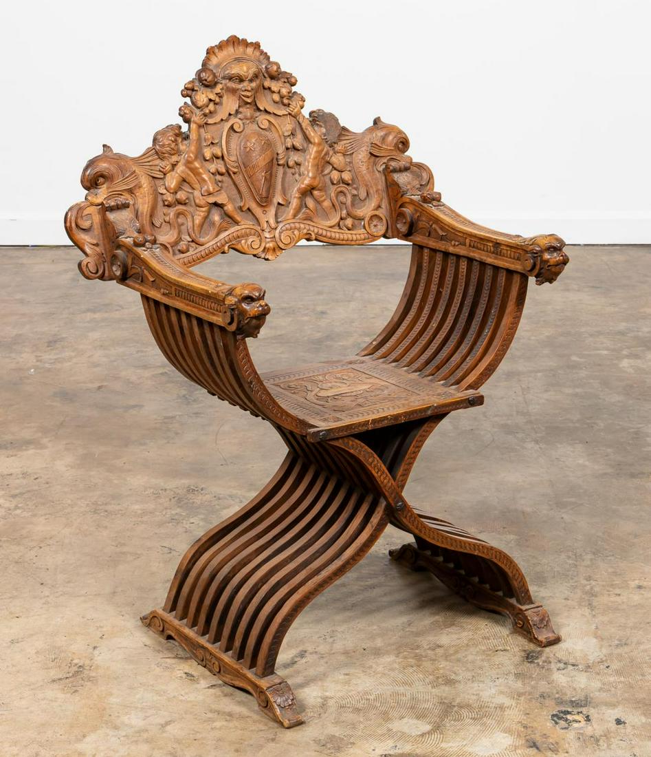 19/2OTH CENTURY ITALIAN SAVONAROLA CHAIR: Italian, late 19th to early 20th century. Carved walnut Savonarola arm chair having a back decorated with putti flanking a coat of arms, dolphins, and mythical beast arms. Approx. h. 41.5”, w. 30.25