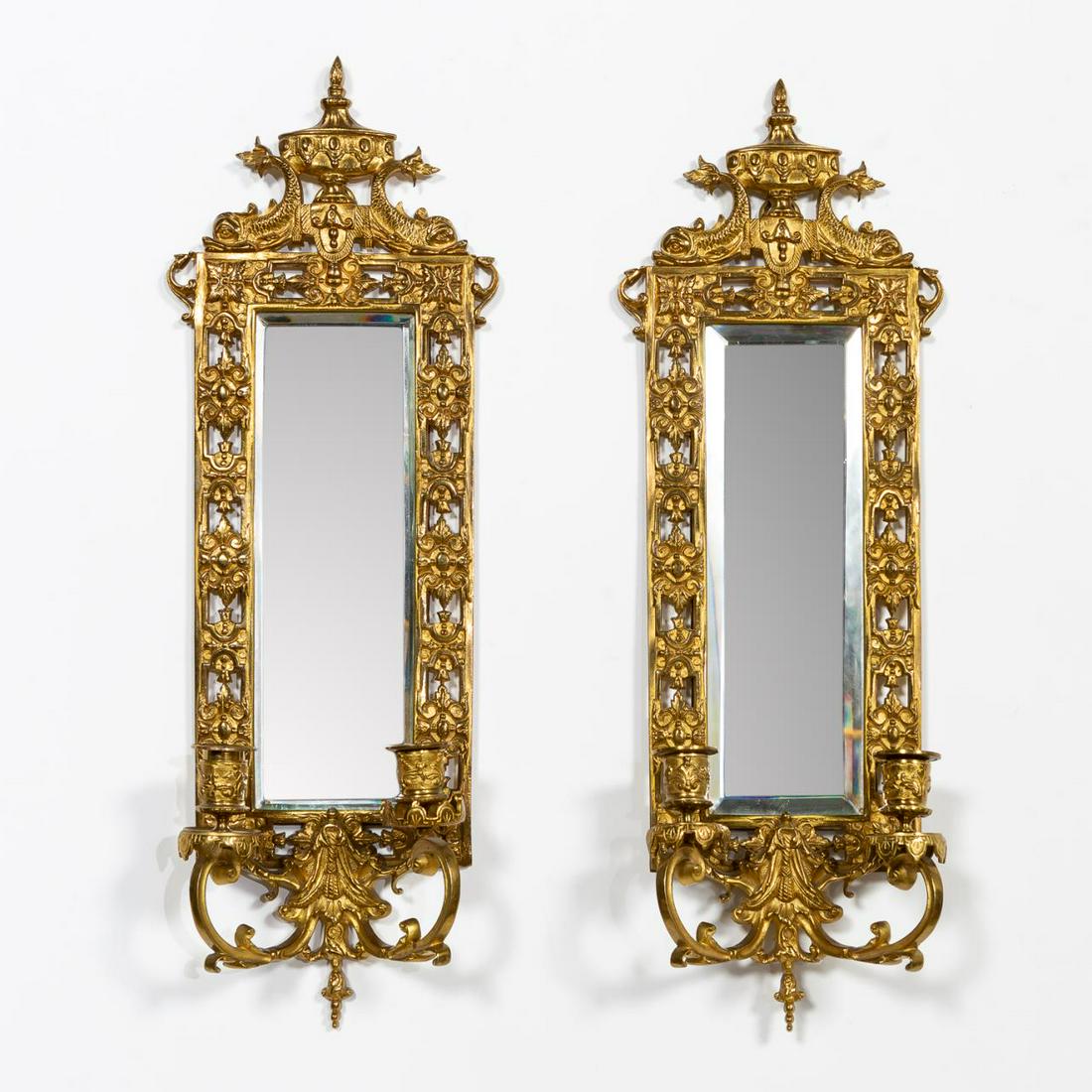 PAIR, NEOCLASSICAL MIRRORED TWO LIGHT SCONCES: Continental, 20th century. Pair gilt metal Neoclassical style two light sconces with pierced borders framing beveled mirror supporting dolphins and urn. Hanging ring verso, apparently unmarked. Approx