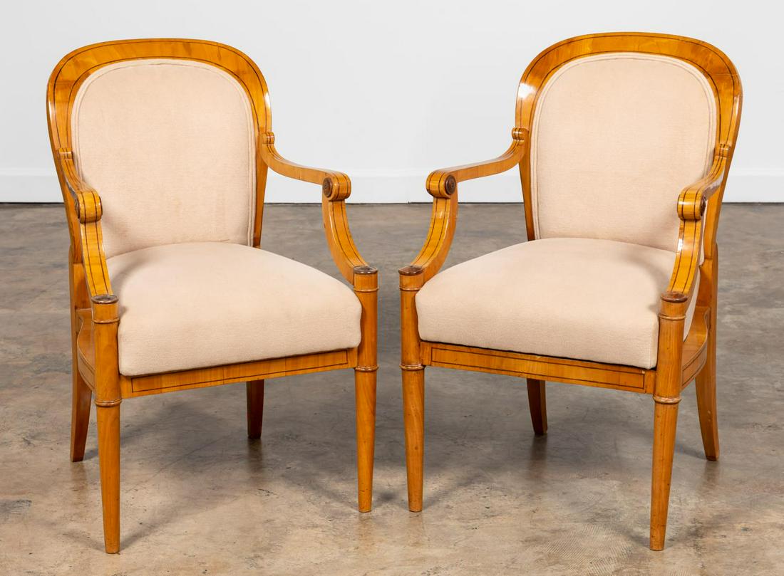 PAIR OF BIEDERMEIER UPHOLSTERED ARMCHAIRS: Continental, 20th century. Pair of Biedermeier style arm chairs having a thin line of ebony inlay, scroll arms, and tapered legs. Apparently unmarked. Approx. h. 35", w. 22.5", d. 21", seat h. 18".